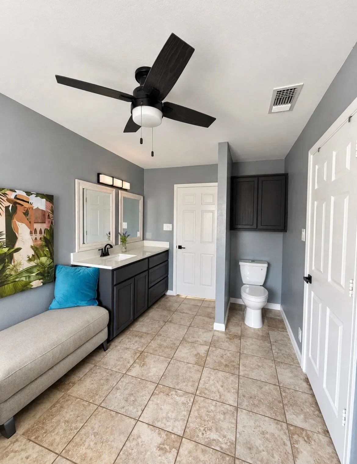 Dual vanity with integrated sinks, tile flooring, built-in cabinetry, and ceiling fan with light fixture