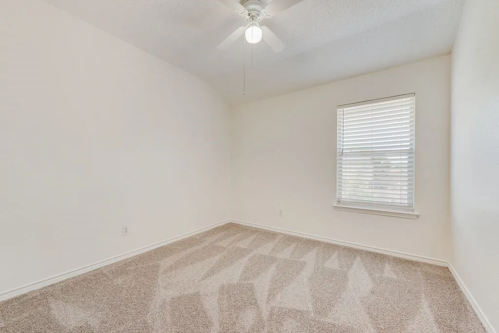 Carpeted room featuring a ceiling fan, window with blinds, and light-toned wall finishes