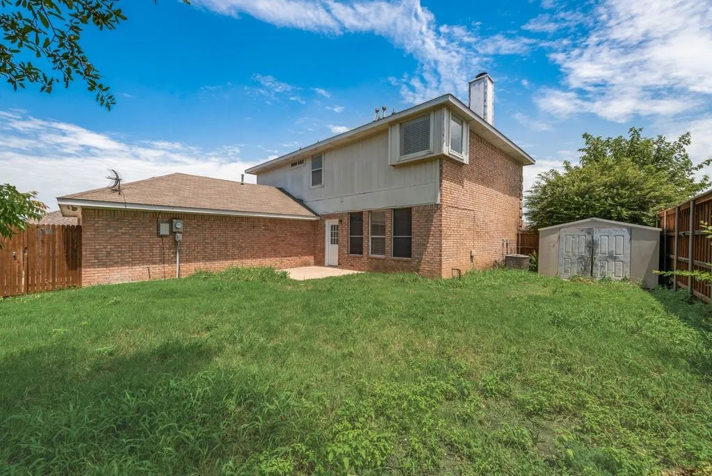 Expansive backyard featuring a brick exterior and a privacy fence