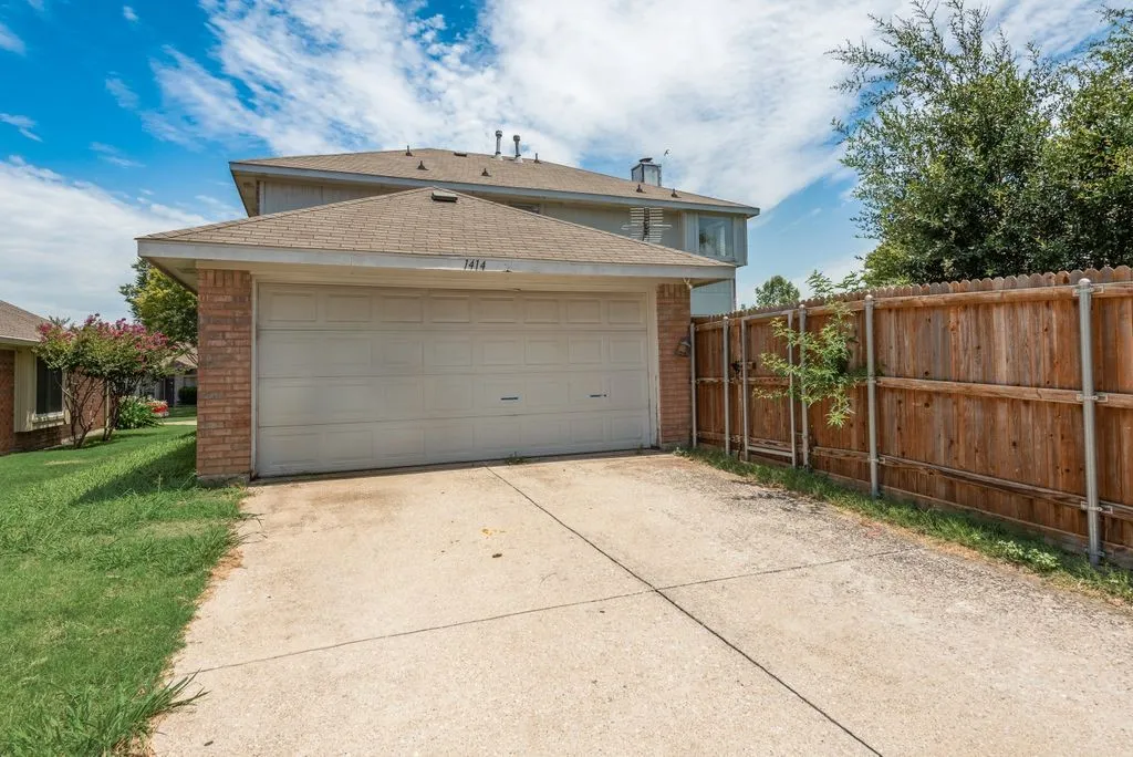 Concrete driveway leading to an attached garage with an automatic door