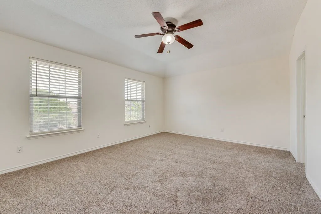 Spacious room featuring neutral carpeting and light-colored walls
