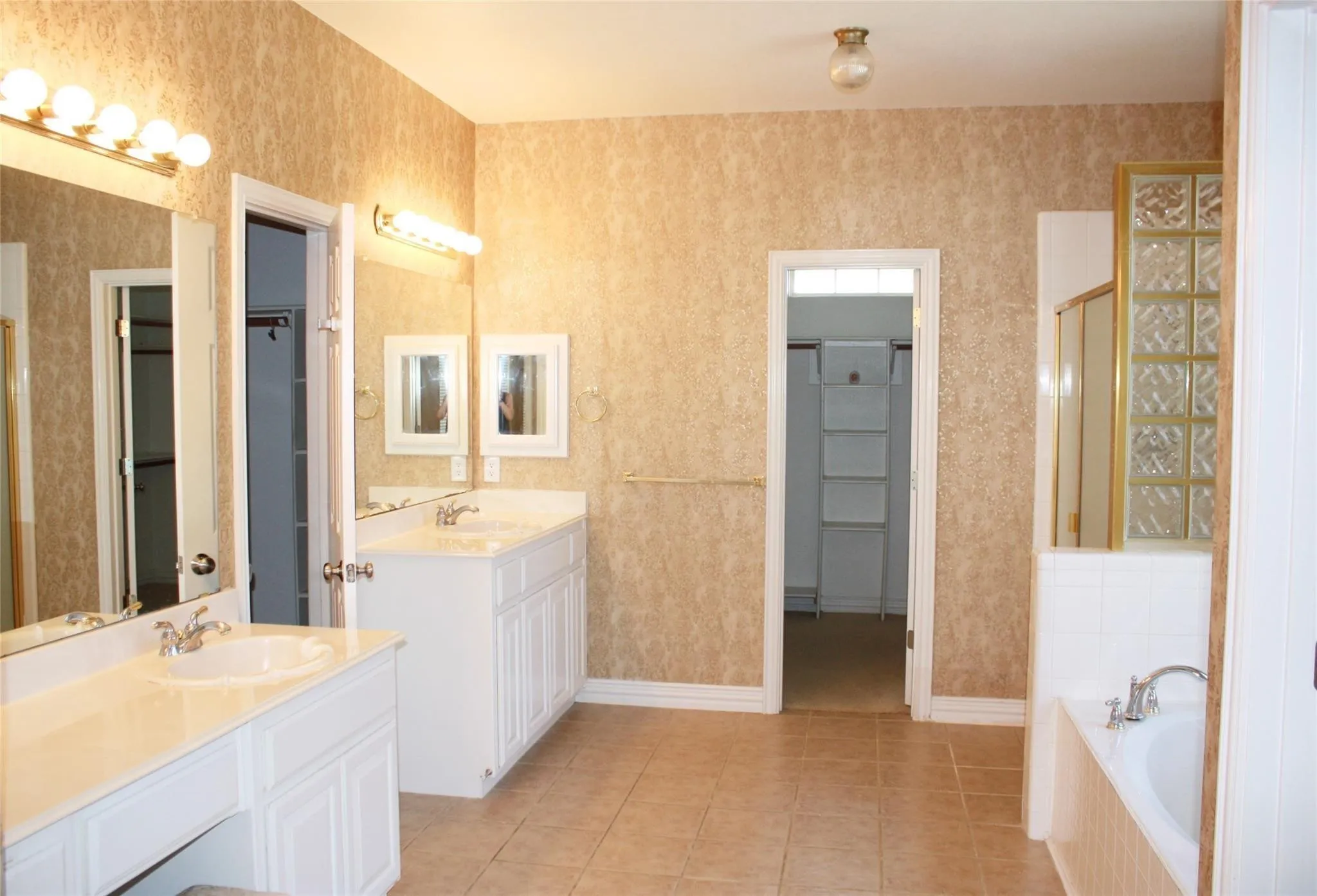 Dual vanity sinks with white cabinetry and integrated countertops