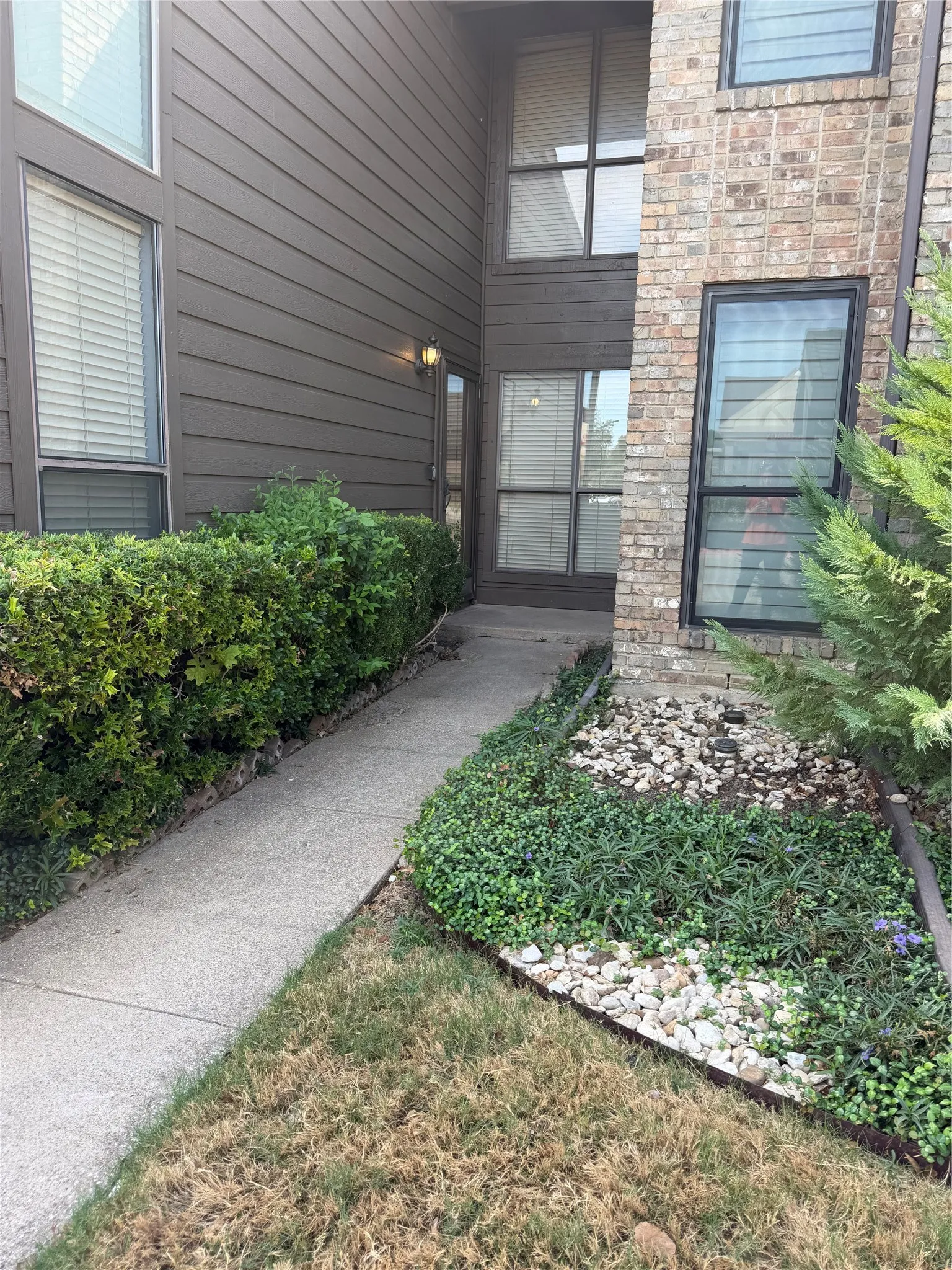 Brick and horizontal siding exterior with a concrete walkway