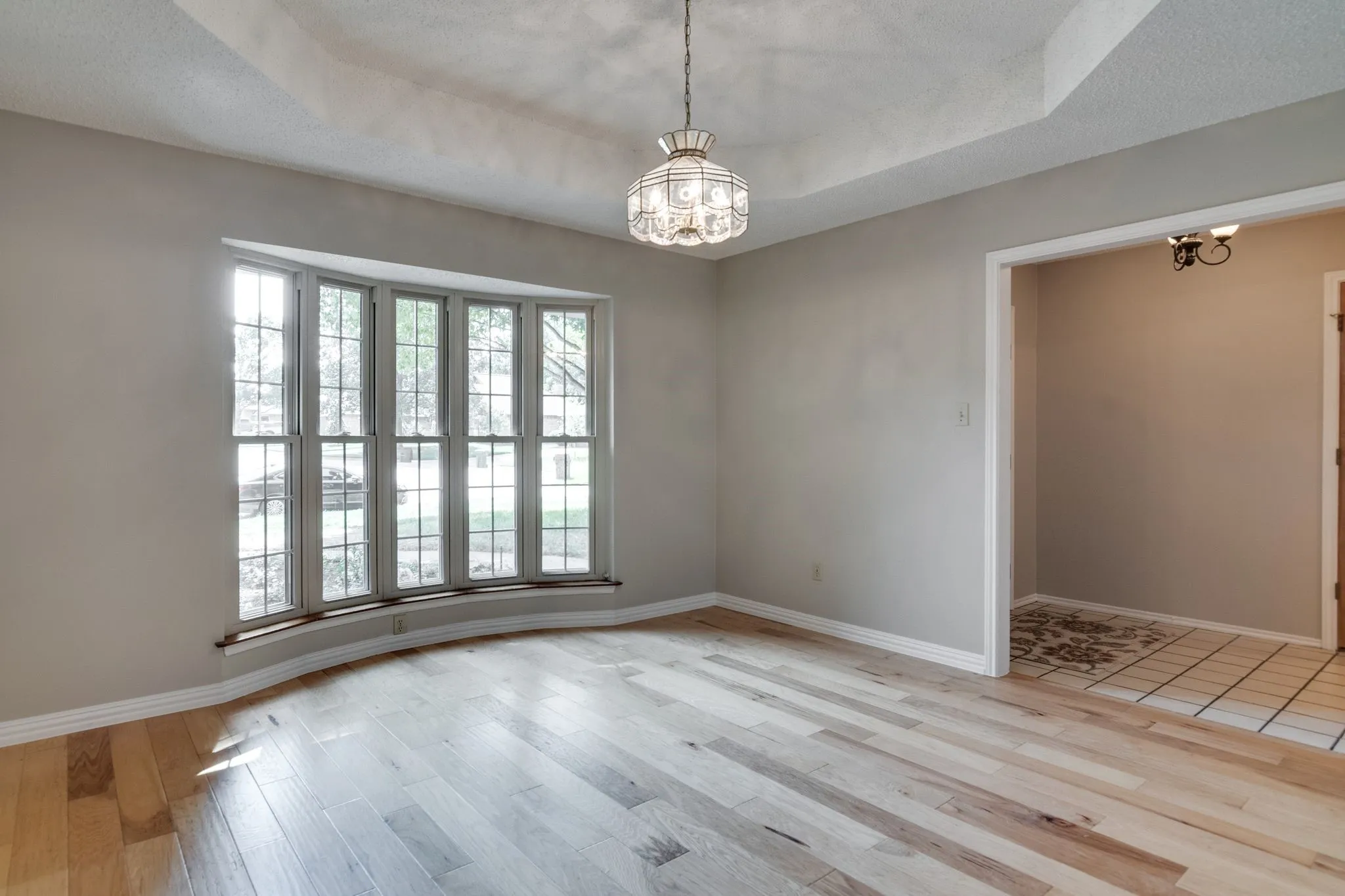 Very spacious formal dining area has pop up ceiling and beautiful bay window overlooking pretty flower garden area!