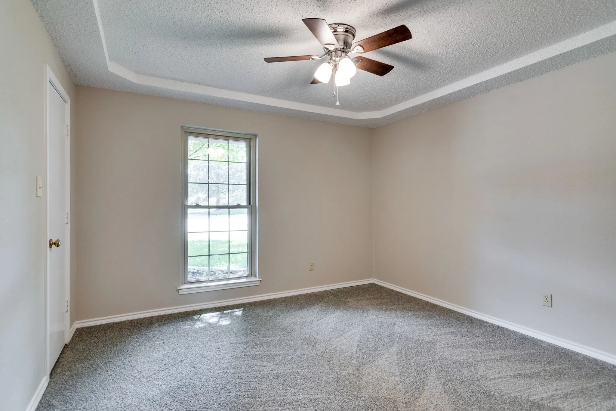 This secondary bedroom overlooks the front yard and has a walk in closet, raised ceiling and new carpet just  installed September 2026