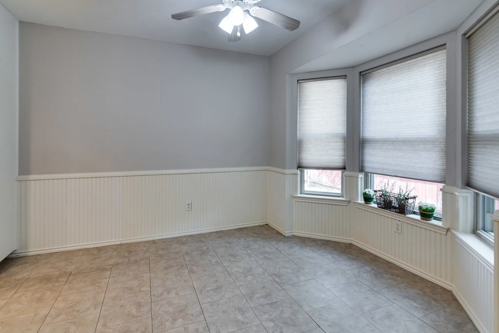 Breakfast nook has wainscotting and bay window.
