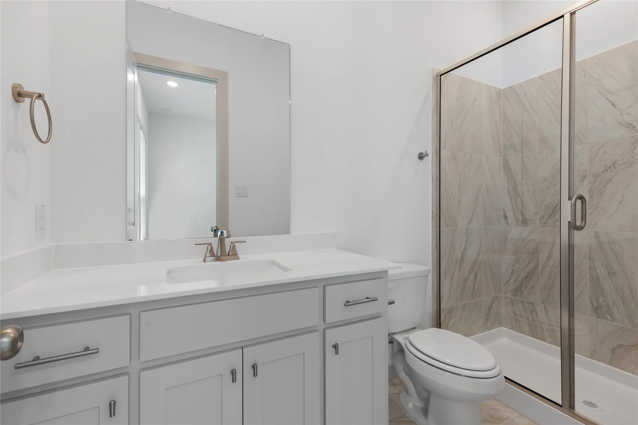 White vanity with a rectangular undermount sink and brushed nickel faucet