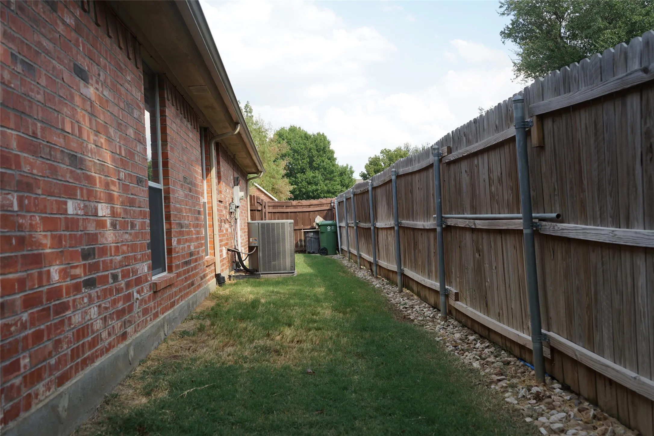 Brick exterior with a privacy fence and gravel border