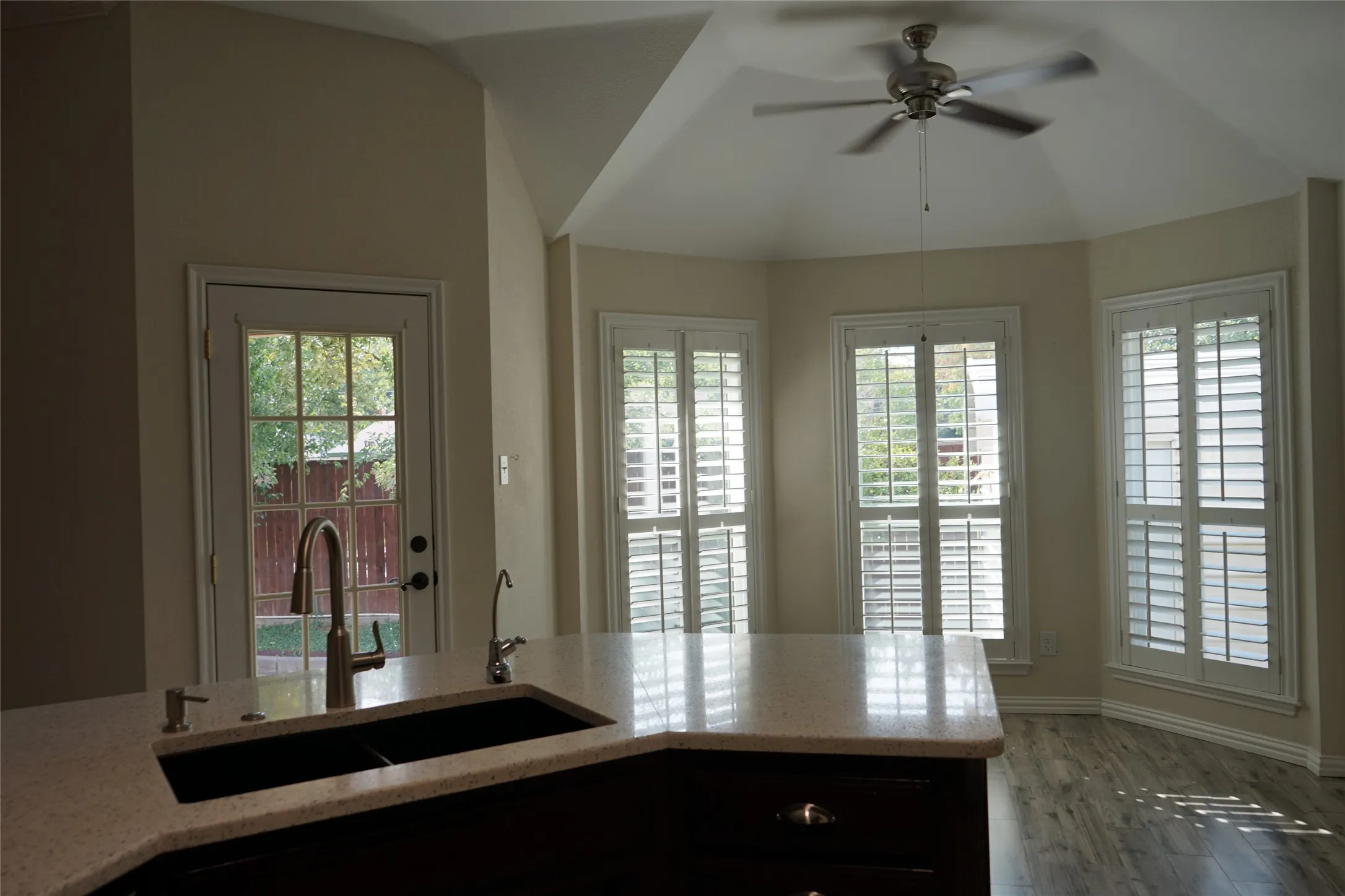 Kitchen island with a built-in double basin sink, gooseneck faucet, and light-toned countertop