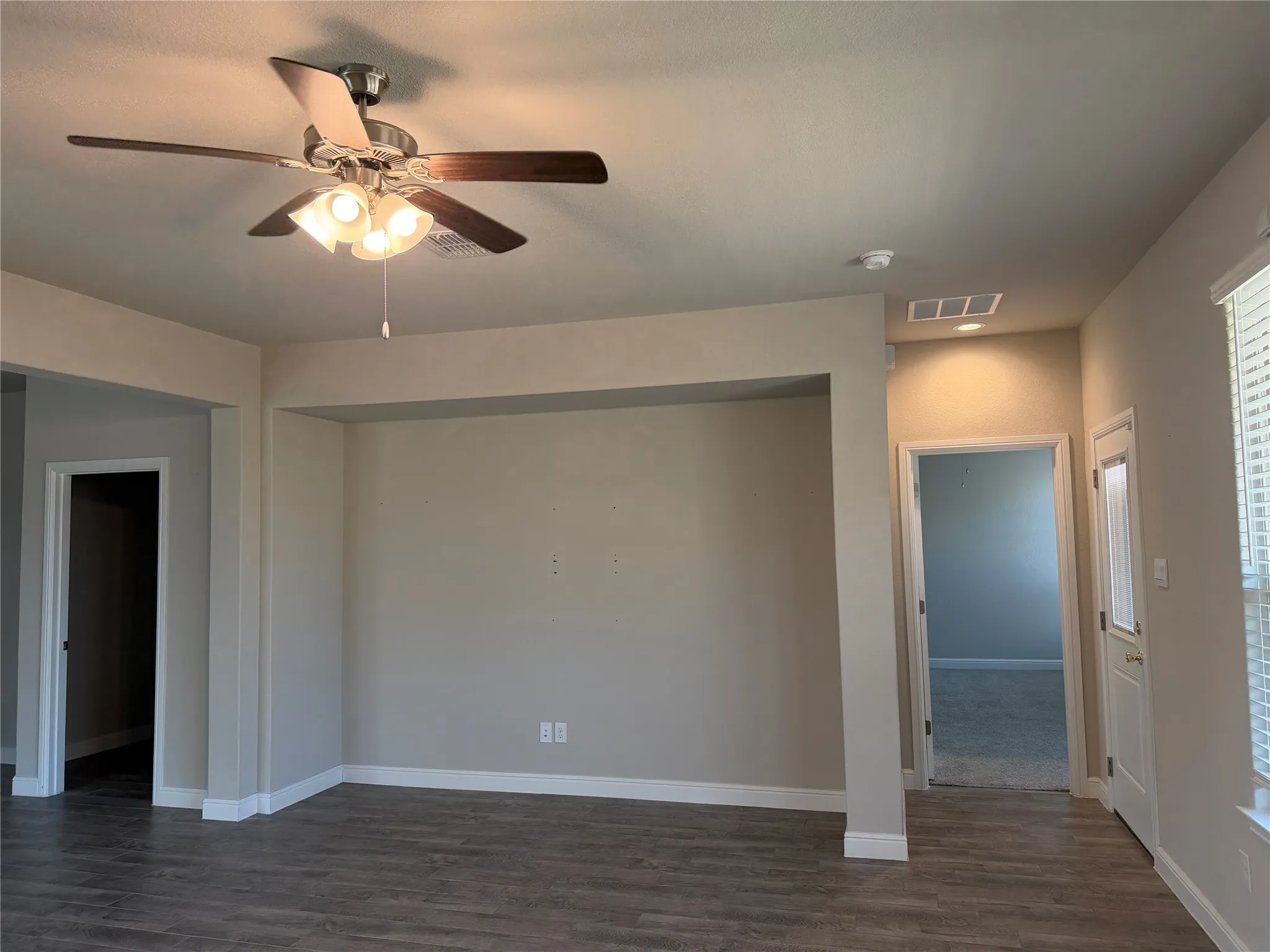 Wood-finish flooring, ceiling fan with integrated lighting, recessed lighting, white window blinds, and neutral wall tones
