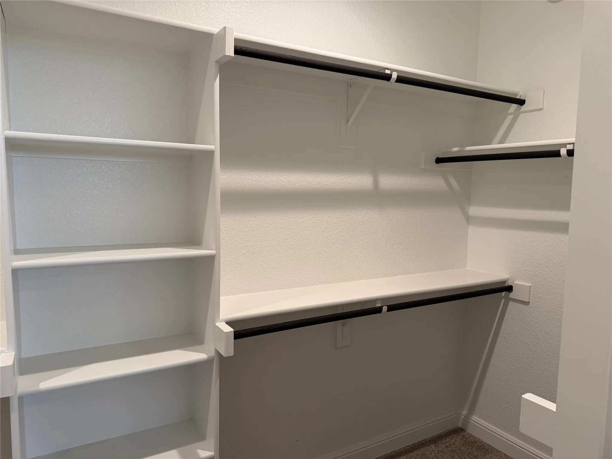 Built-in shelving, multiple hanging rods, and an integrated storage system