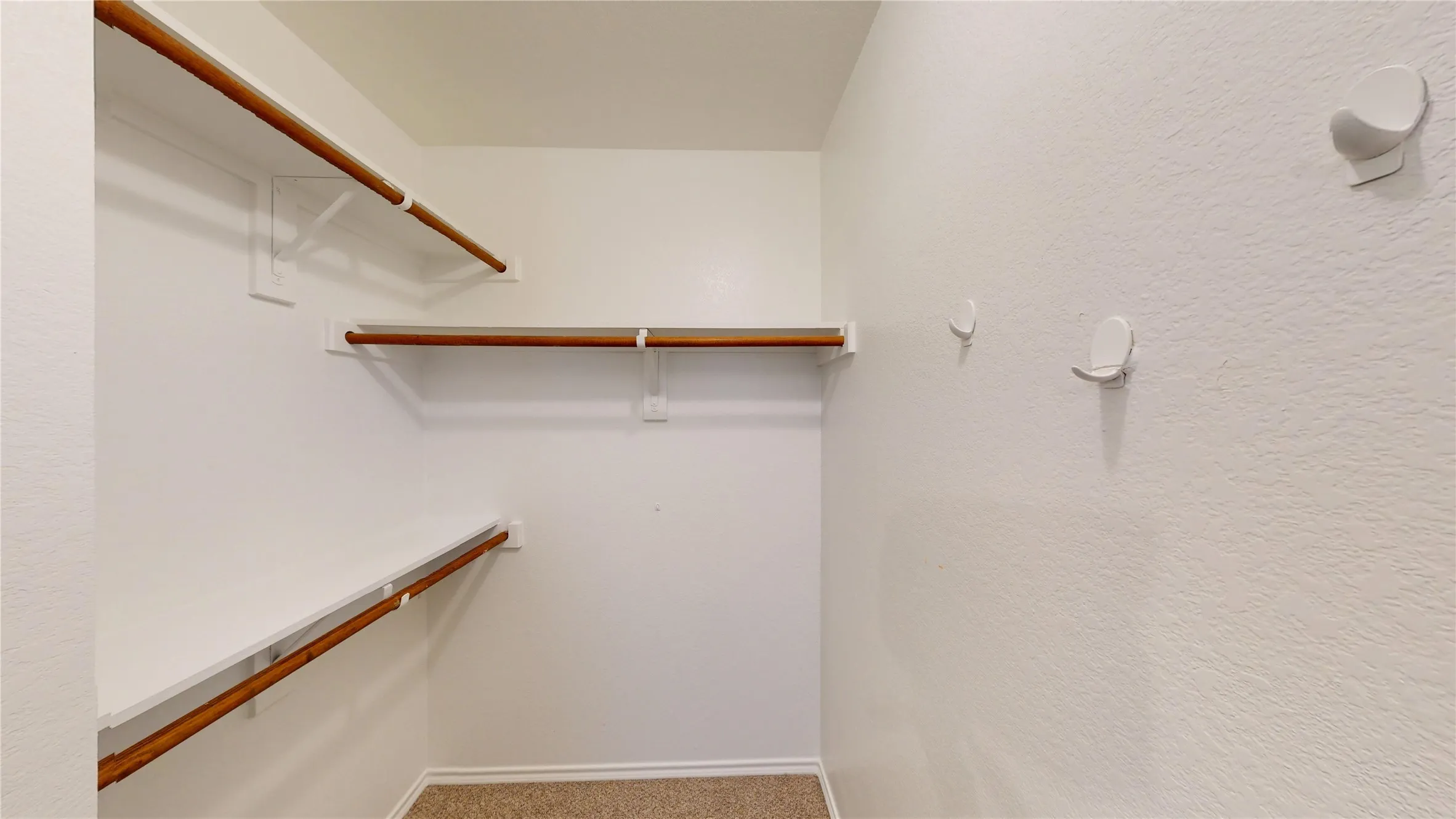 Multiple built-in shelving units, integrated clothing rods, and wall-mounted hooks