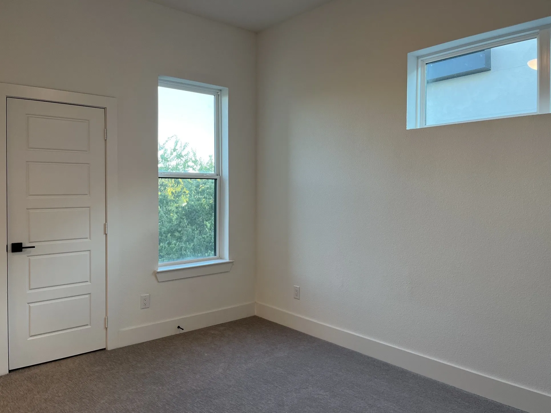 Secondary Bedroom. Soft gray carpet flooring, white walls, and walk-in closet