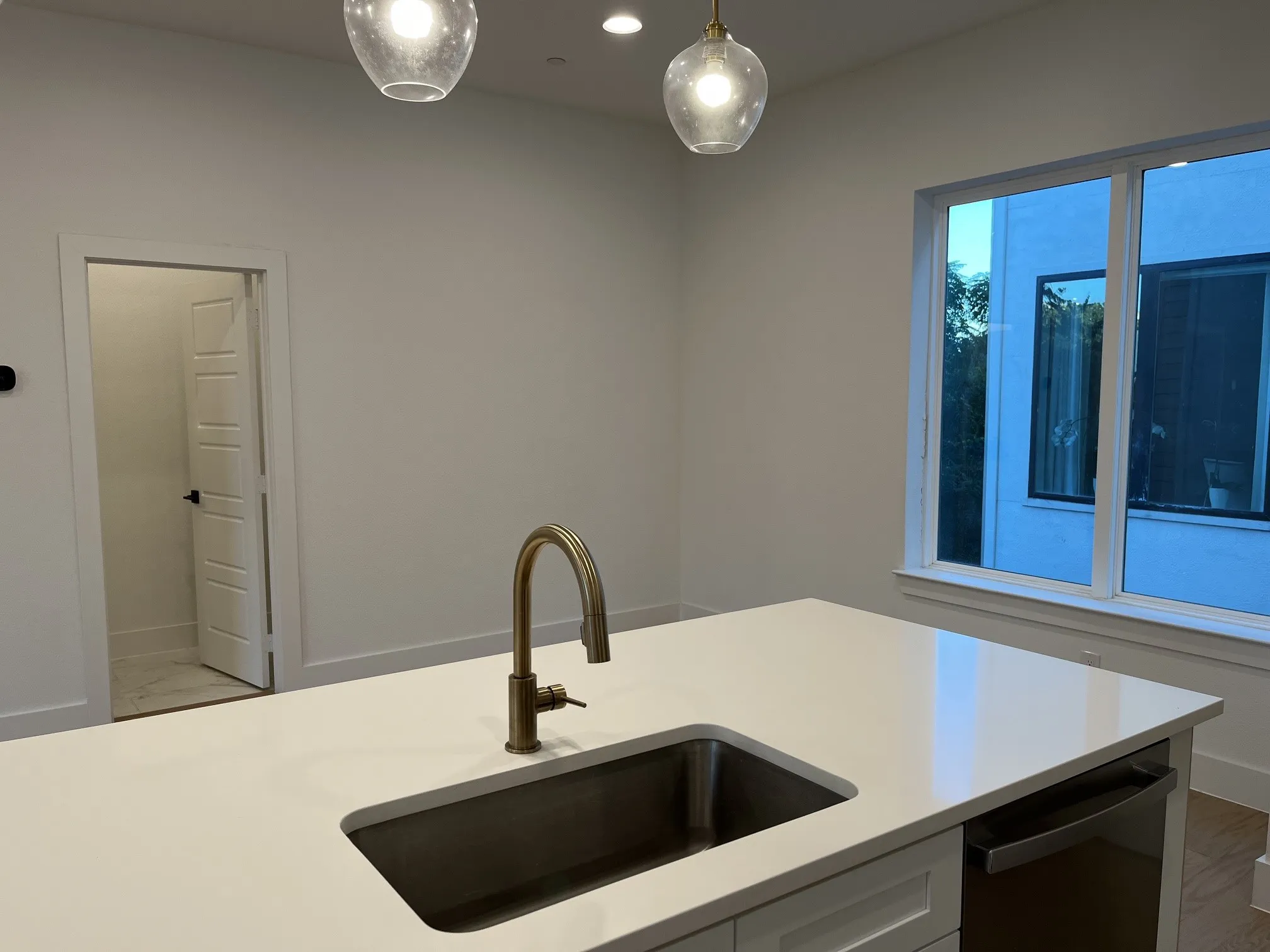 Kitchen island with an undermount sink, gooseneck faucet, and integrated dishwasher