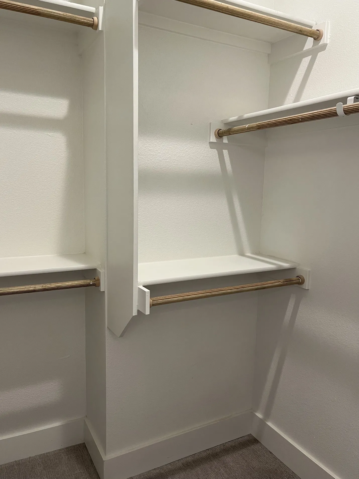Built-in closet system in Primary bathroom
featuring multiple shelves and hanging rods