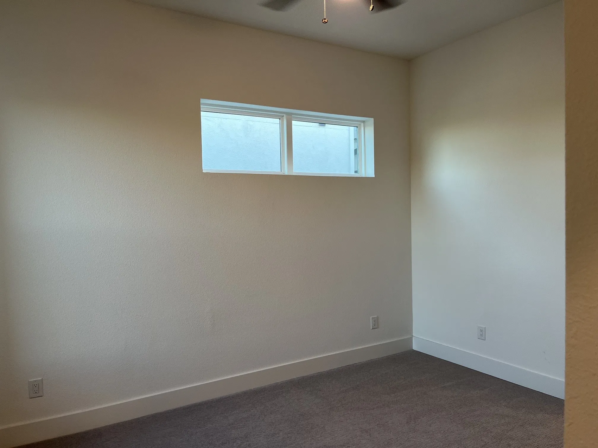 Carpeted secondary bedroom featuring a high window, neutral wall tones, and white​​‌​​​​‌​​‌‌​‌‌​​​‌‌​‌​‌​‌​​​‌​​ trim