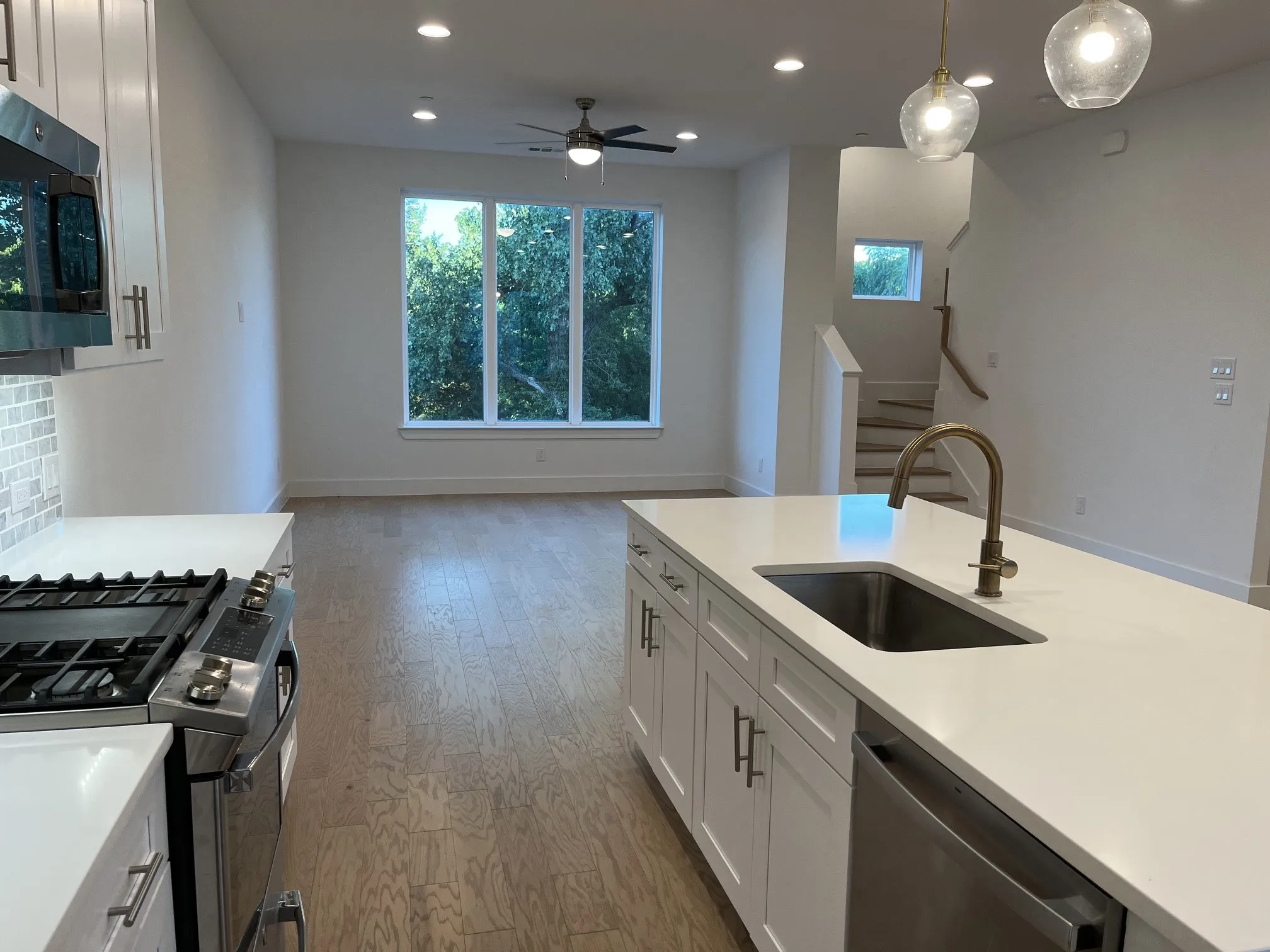 Modern kitchen featuring a large island with an undermount sink and a gooseneck faucet