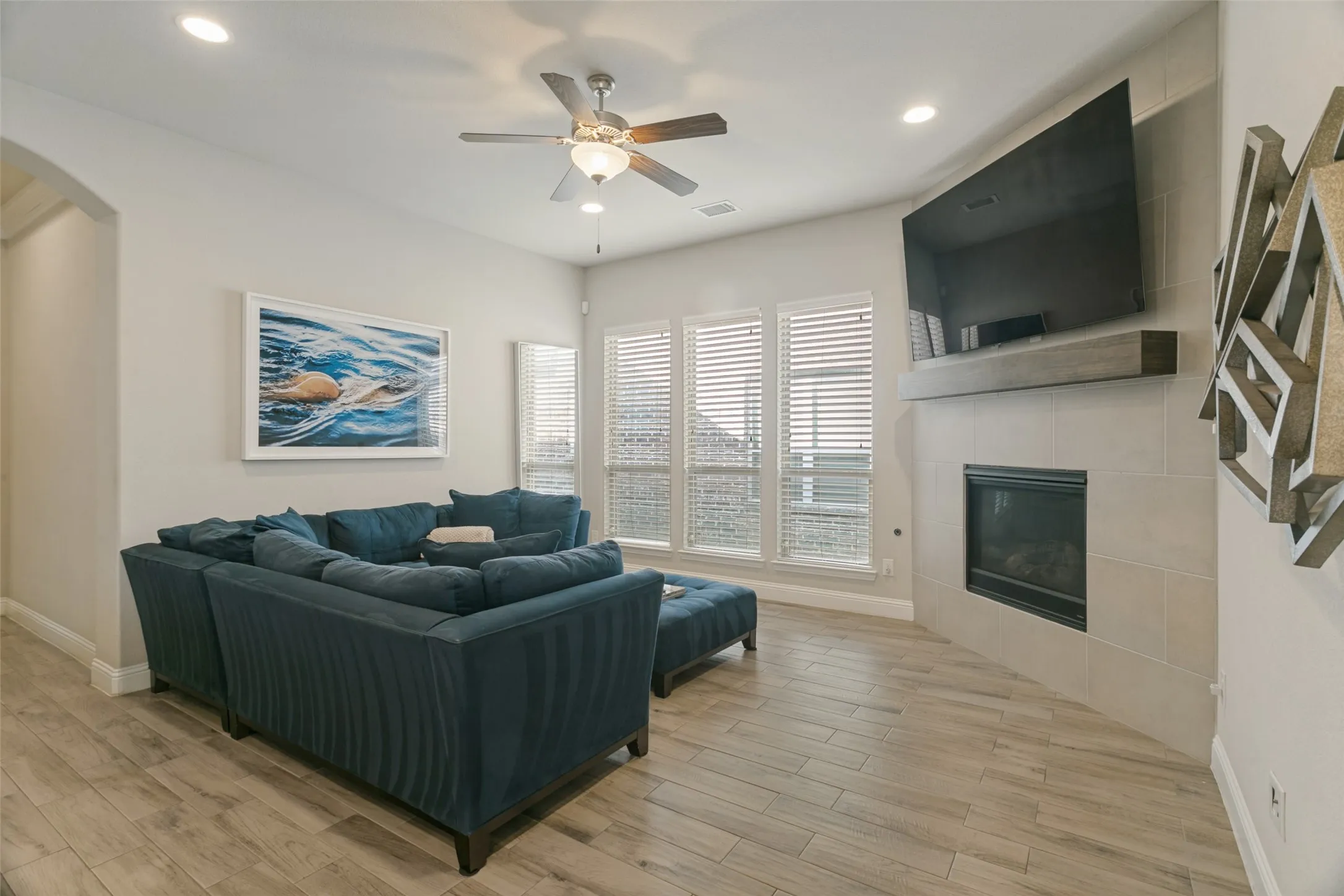 Angled fireplace with a wood-finish mantel and tile surround