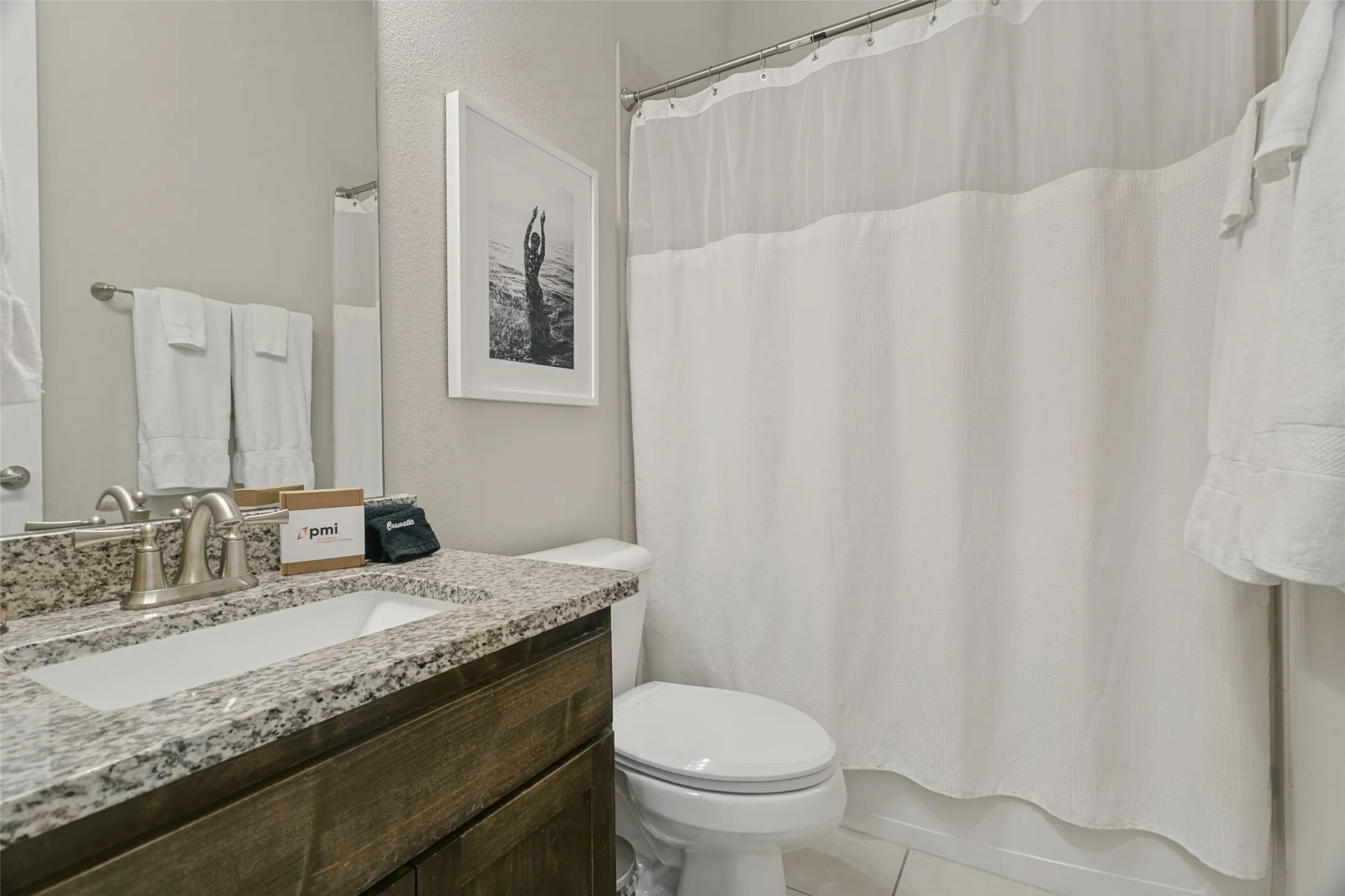 Vanity with a granite countertop, undermount sink, and wood-finish cabinetry