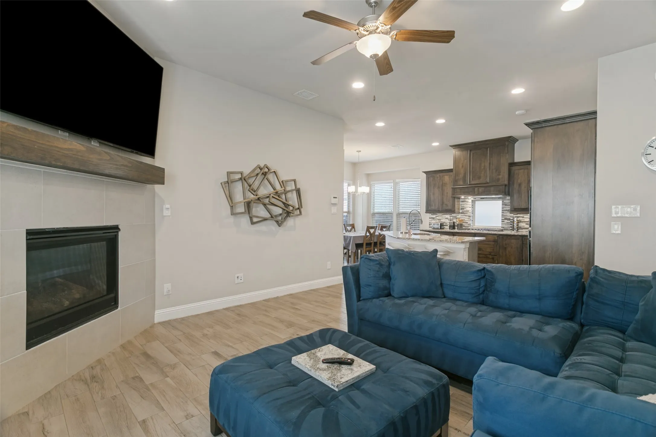 Recessed lighting, wood-finish flooring, and a ceiling fan with integrated light