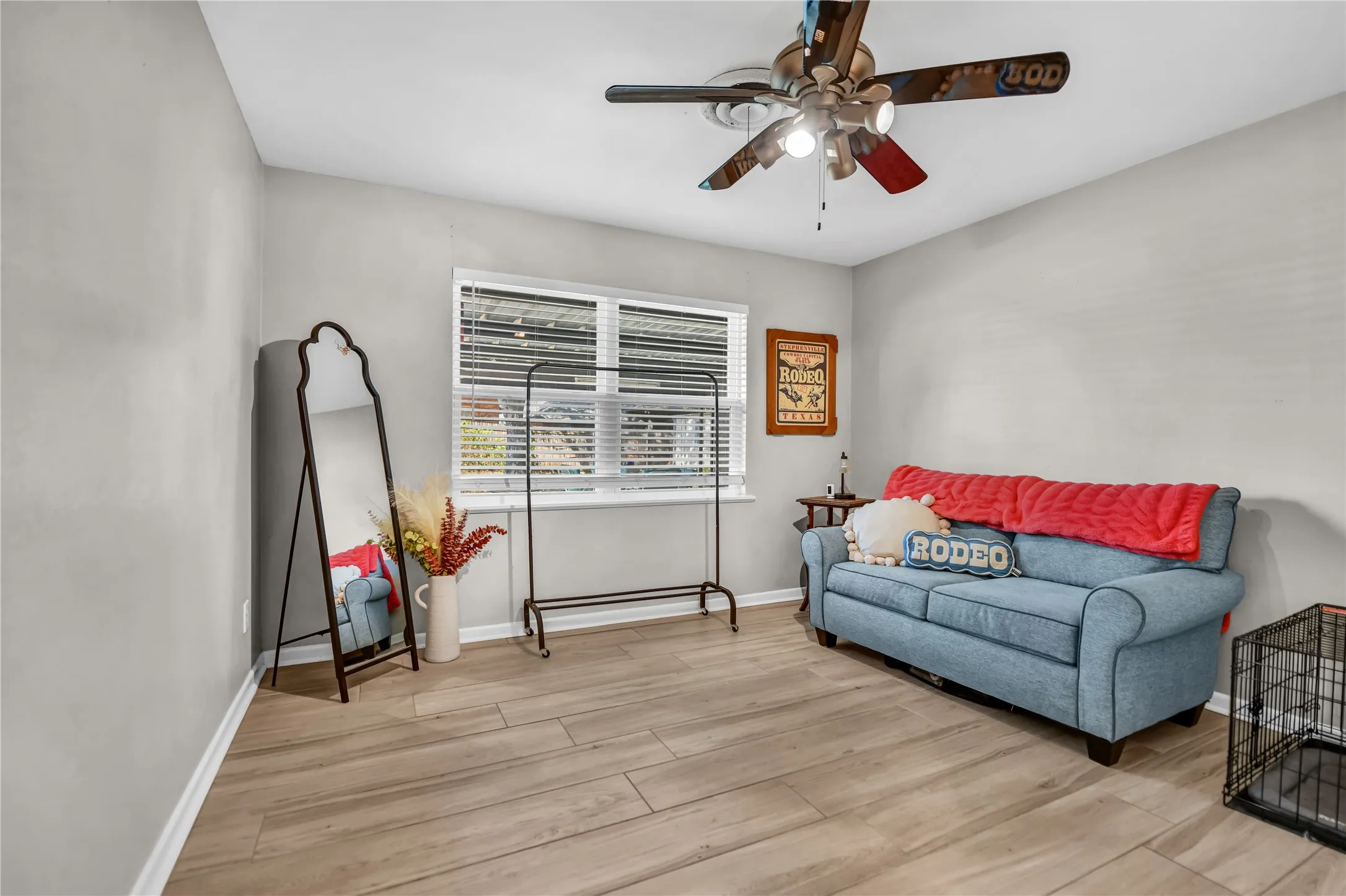 Wood-finish flooring, ceiling fan with integrated lighting, and a window with blinds