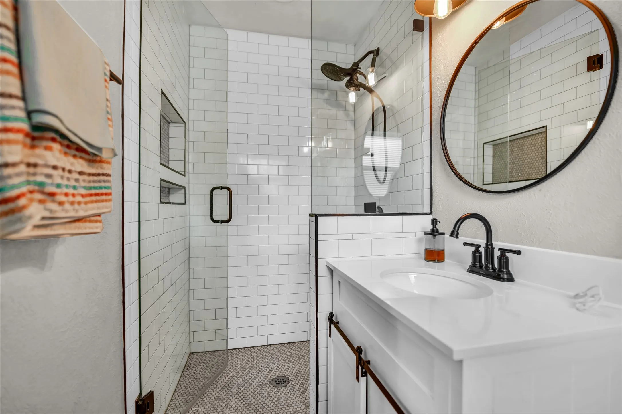 Walk-in shower with subway tile surround and integrated niches