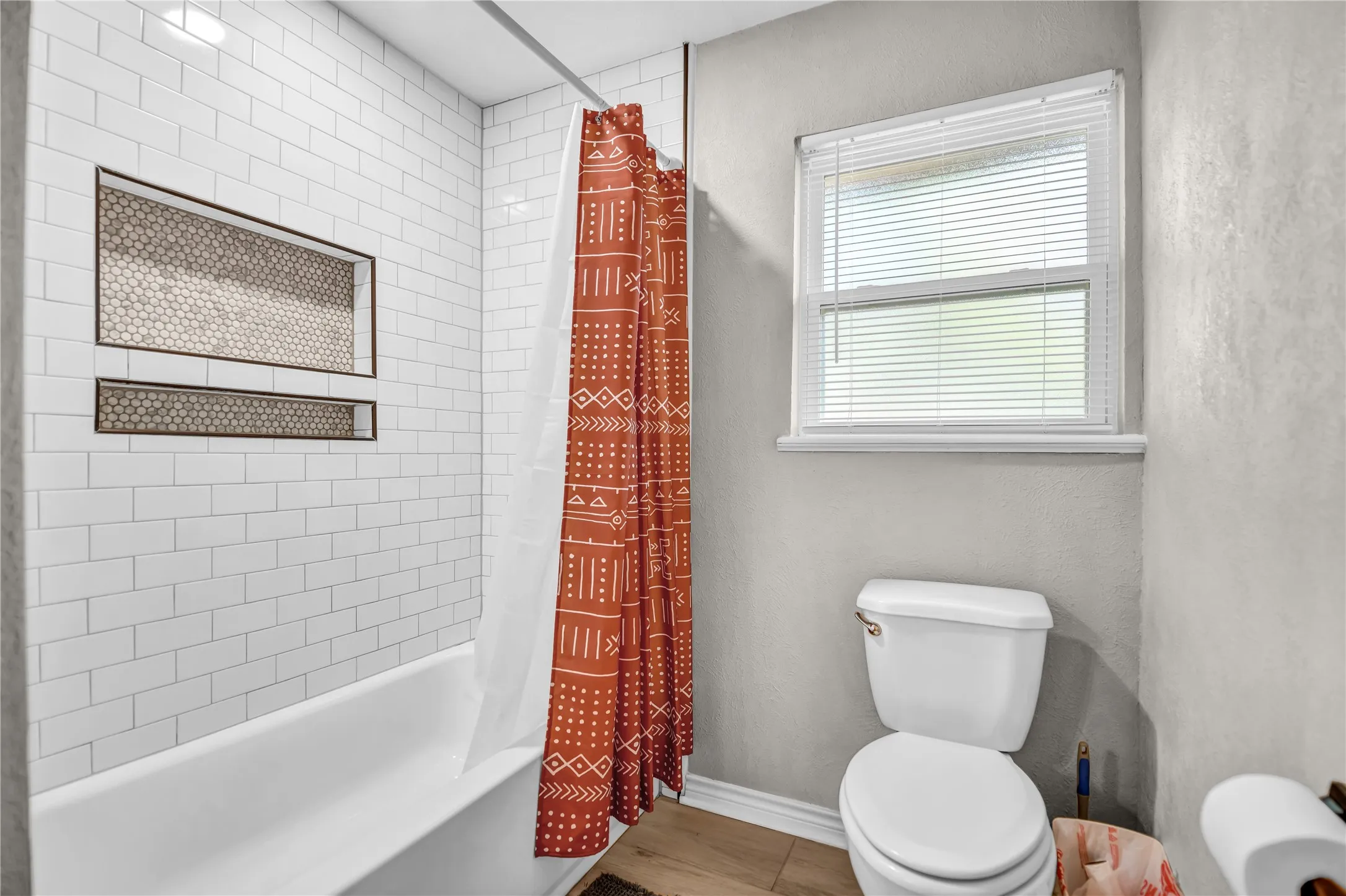 White subway tile shower surround with dual recessed niches featuring mosaic tile