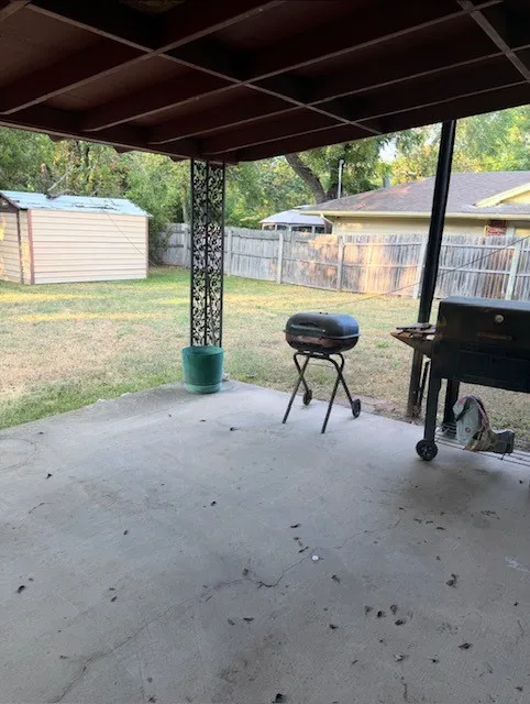 Covered patio with a concrete surface, featuring an ornate metal support column
