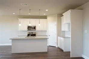 Kitchen featuring a central island, white cabinetry, recessed lighting, pendant lighting, and wood-finish flooring