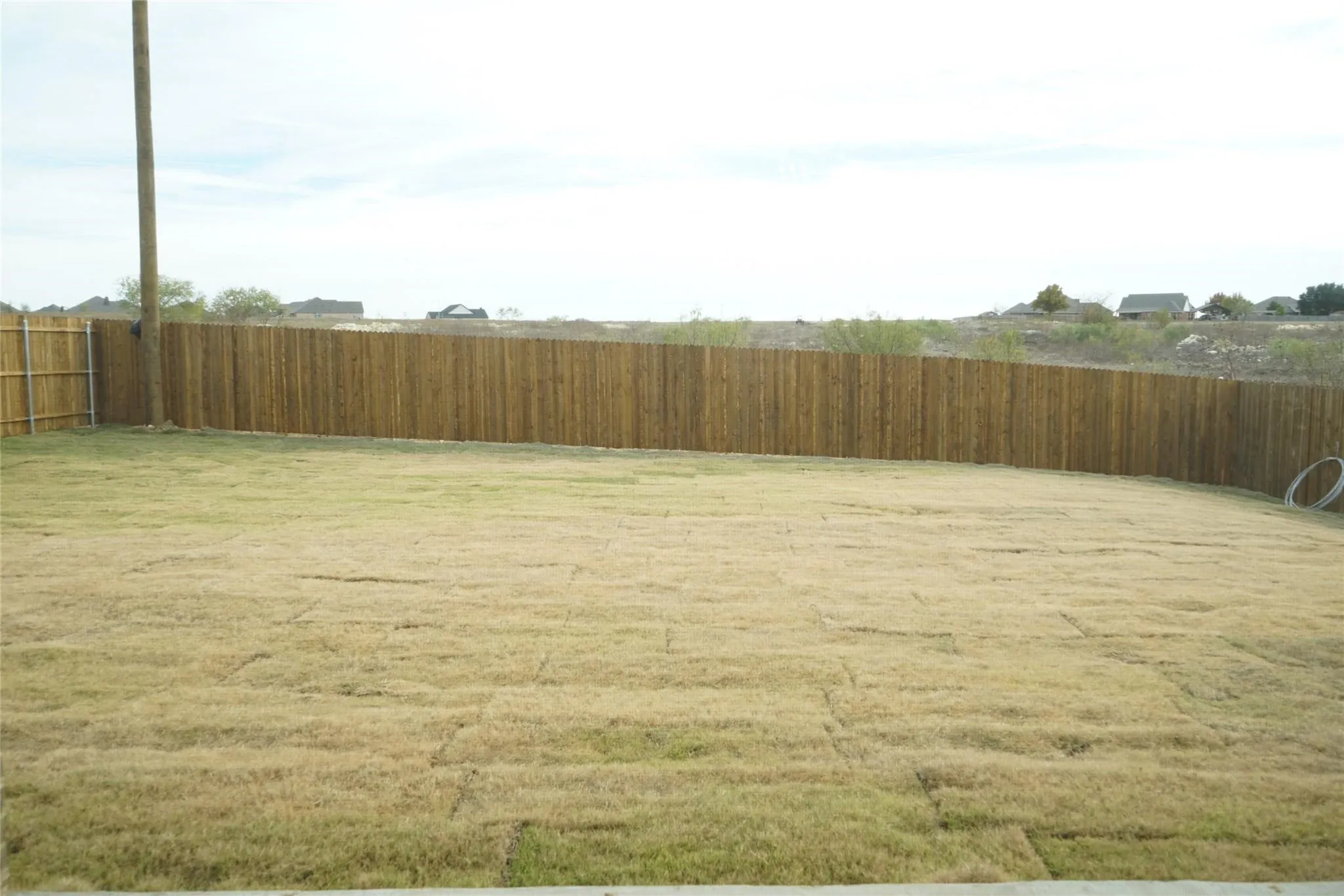 Expansive backyard featuring a natural wood privacy fence