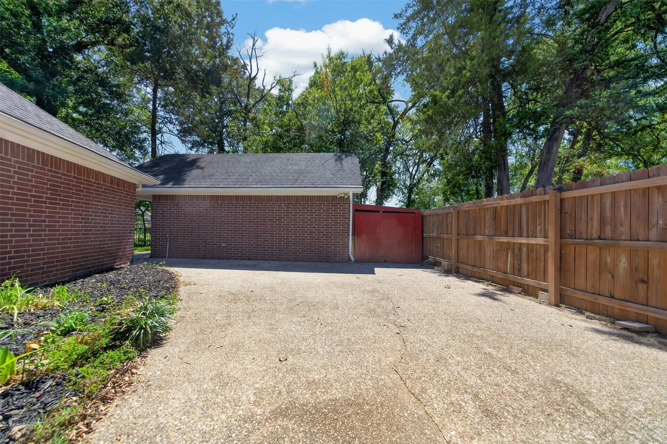 HOA requires the RV to be behind Fencing.  This area was created for that purpose.  Notice the Red Wood which s the opening to the area behind the Workshop for additional storage of mowers and etc.