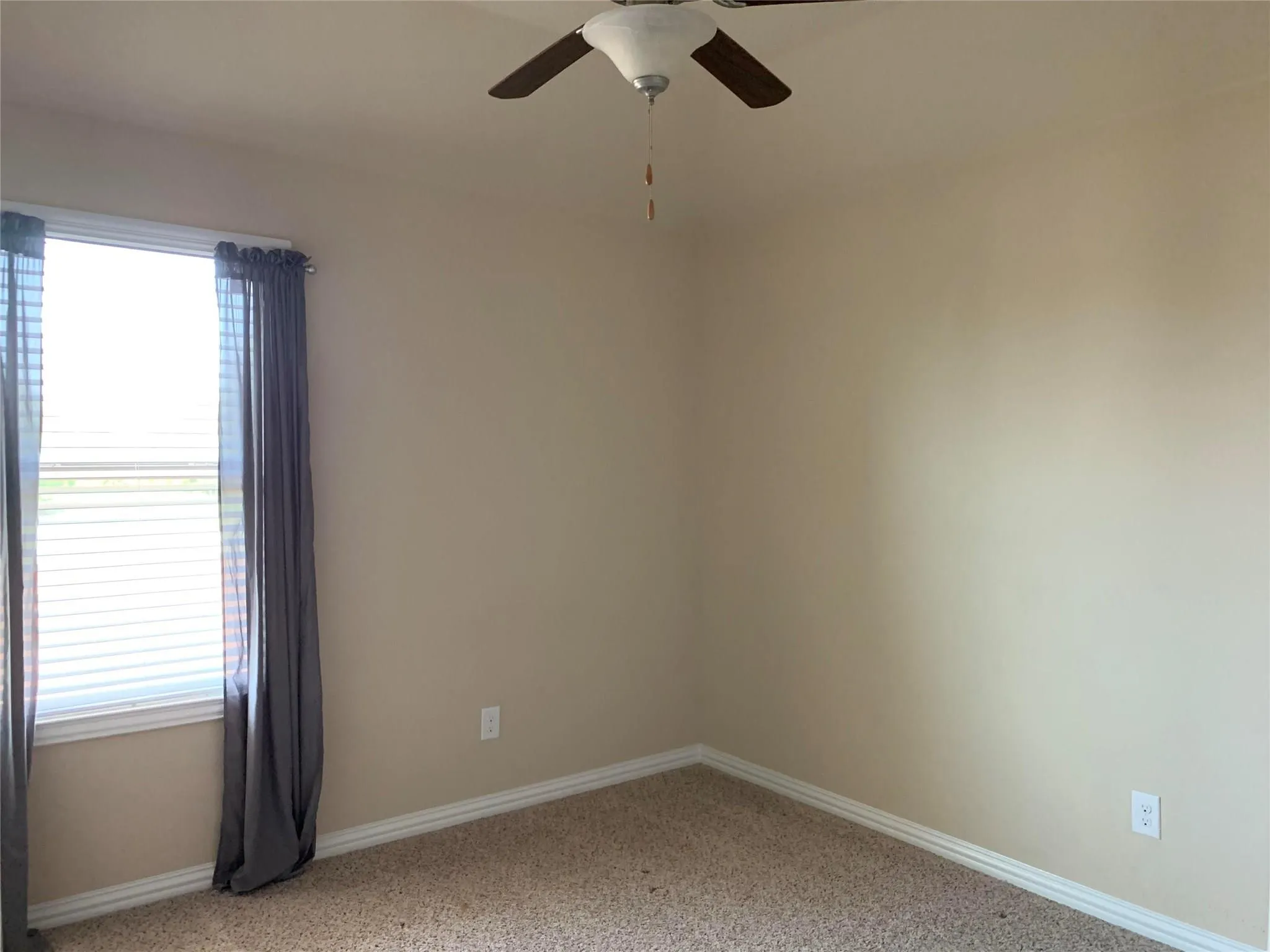 Recessed window with blinds, ceiling fan with integrated lighting, and neutral carpeting
