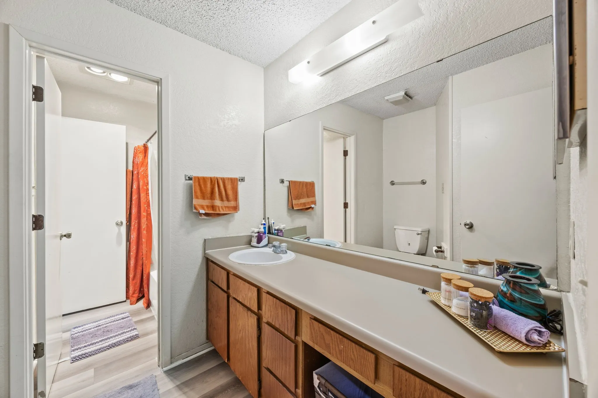 Single vanity with an integrated sink and wood-finish cabinetry