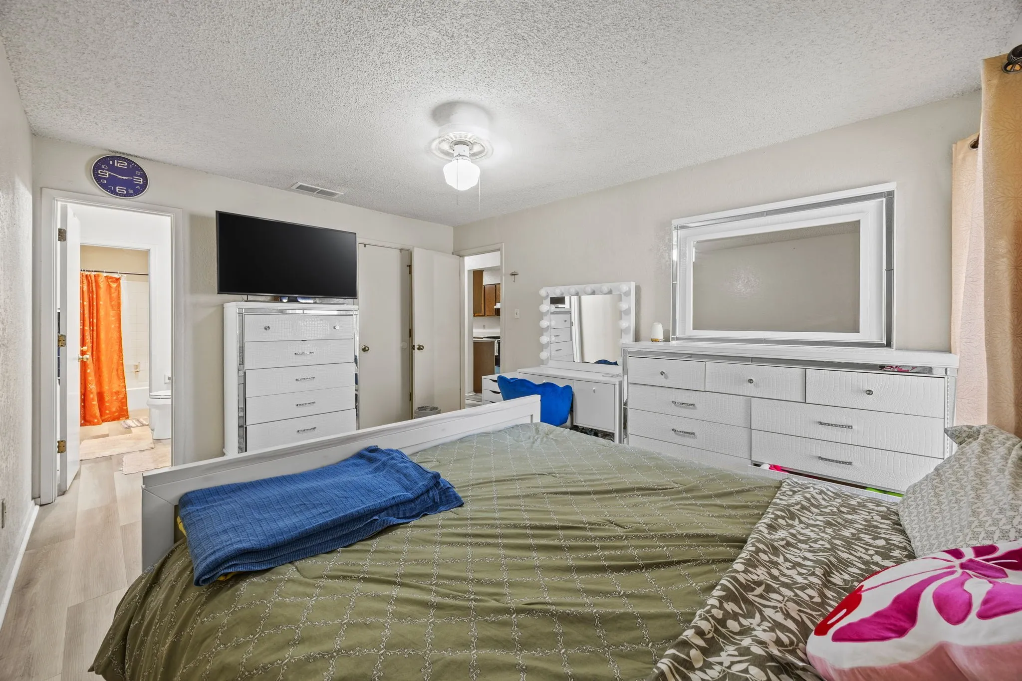 Wood-finish flooring with white walls and a ceiling fan
