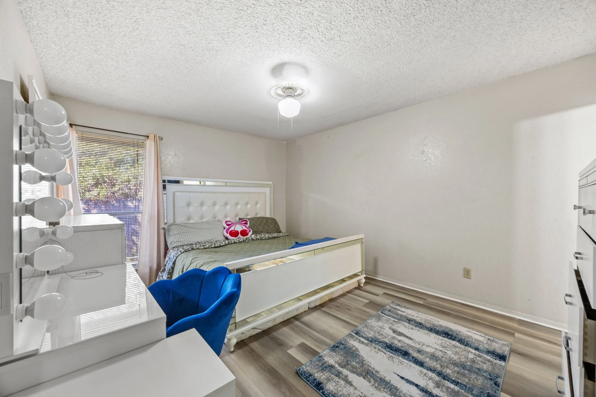 Wood-finish flooring with white walls and a window with natural light