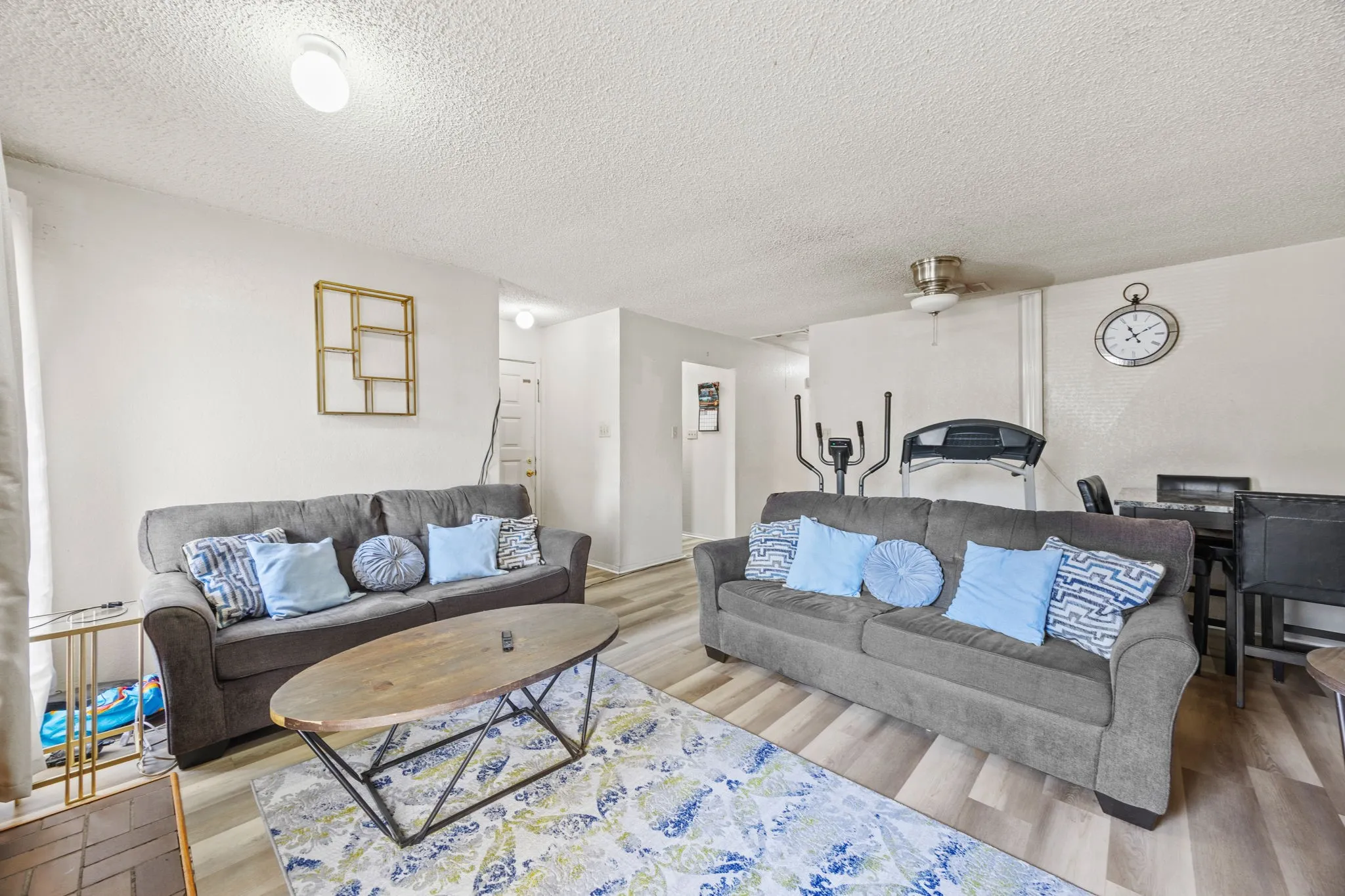 Spacious living area featuring light-toned walls, wood-finish flooring, and recessed lighting
