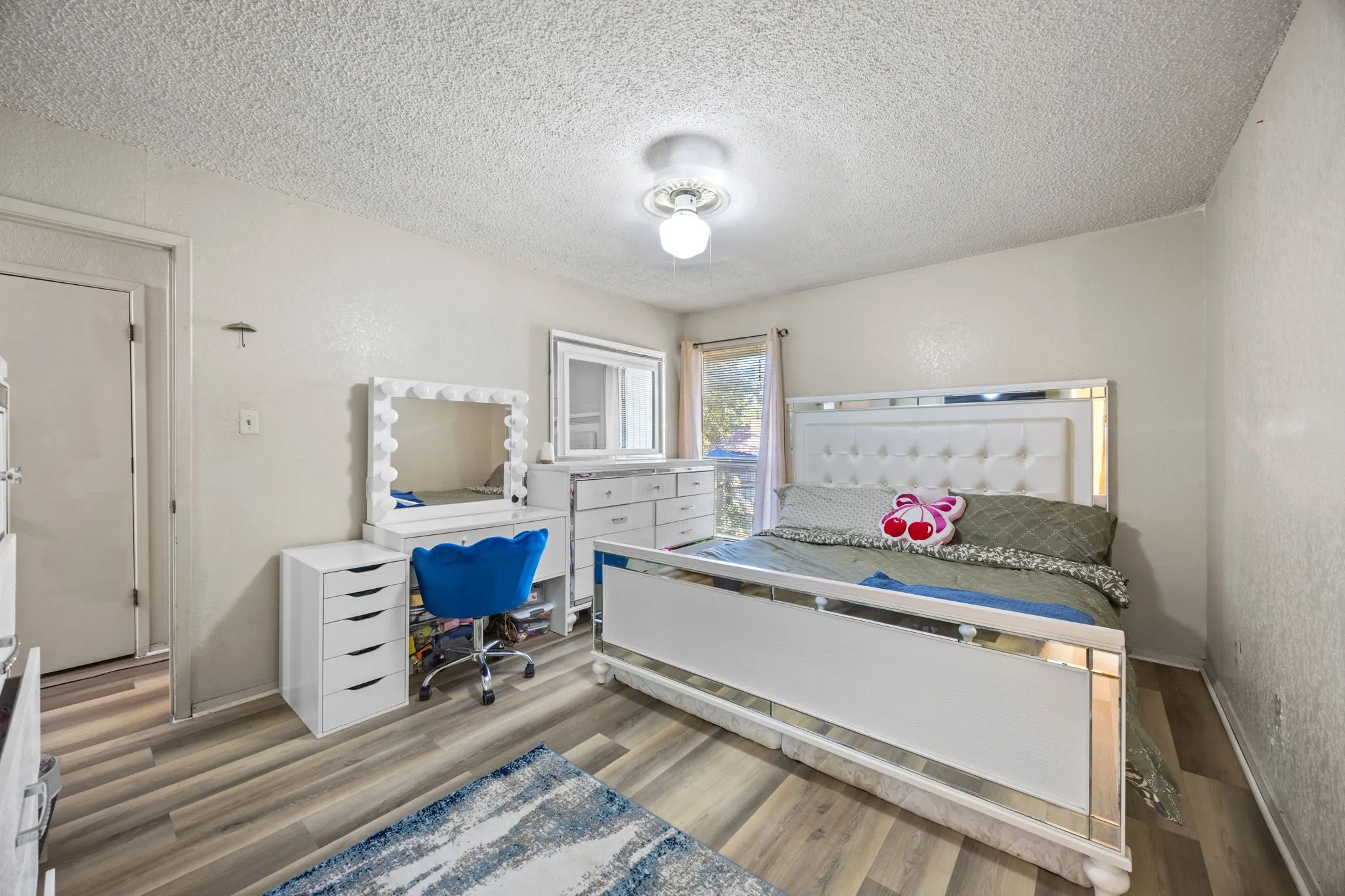 Wood-finish flooring, light-colored walls, and a ceiling-mounted light fixture