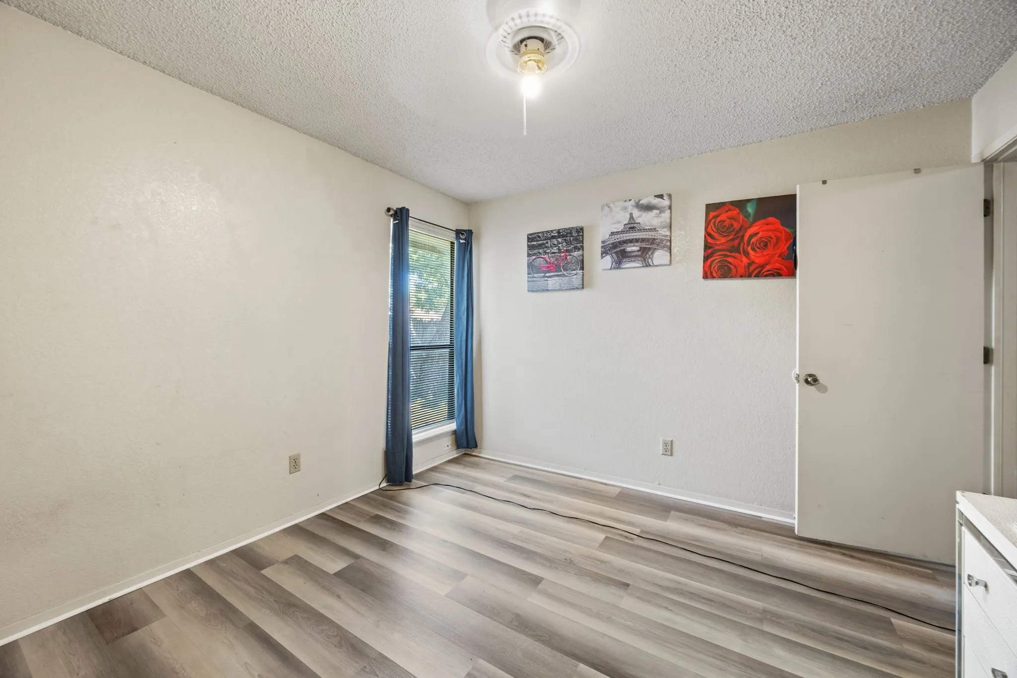 Wood-finish flooring with a window offering natural light