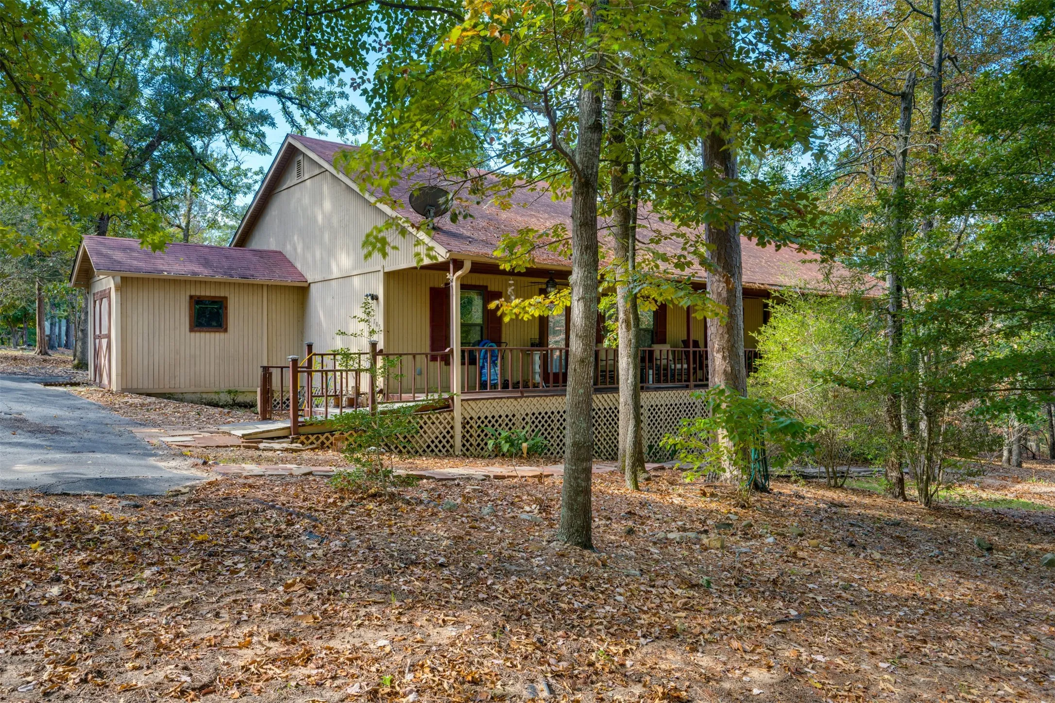 Siding exterior with a covered porch, wood railing, and a detached storage structure