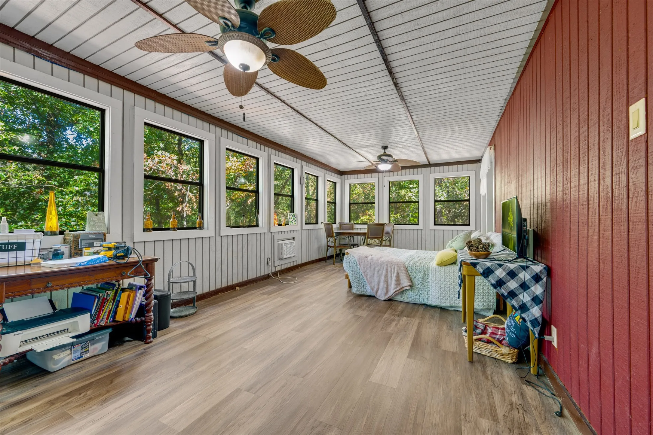 Wood-finish flooring with multiple windows and two ceiling fans
