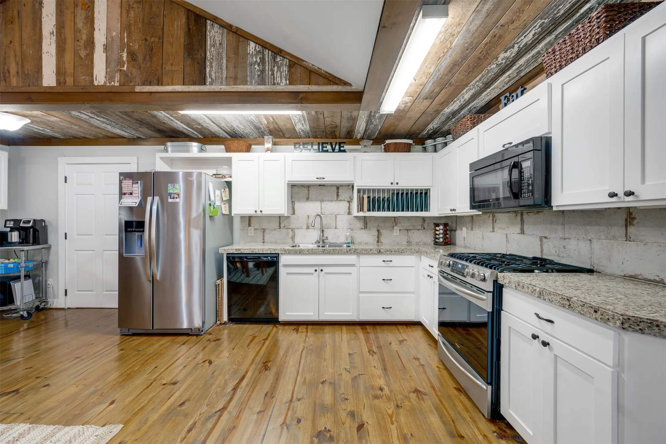 Wood-finish flooring with white cabinetry and light-toned countertops