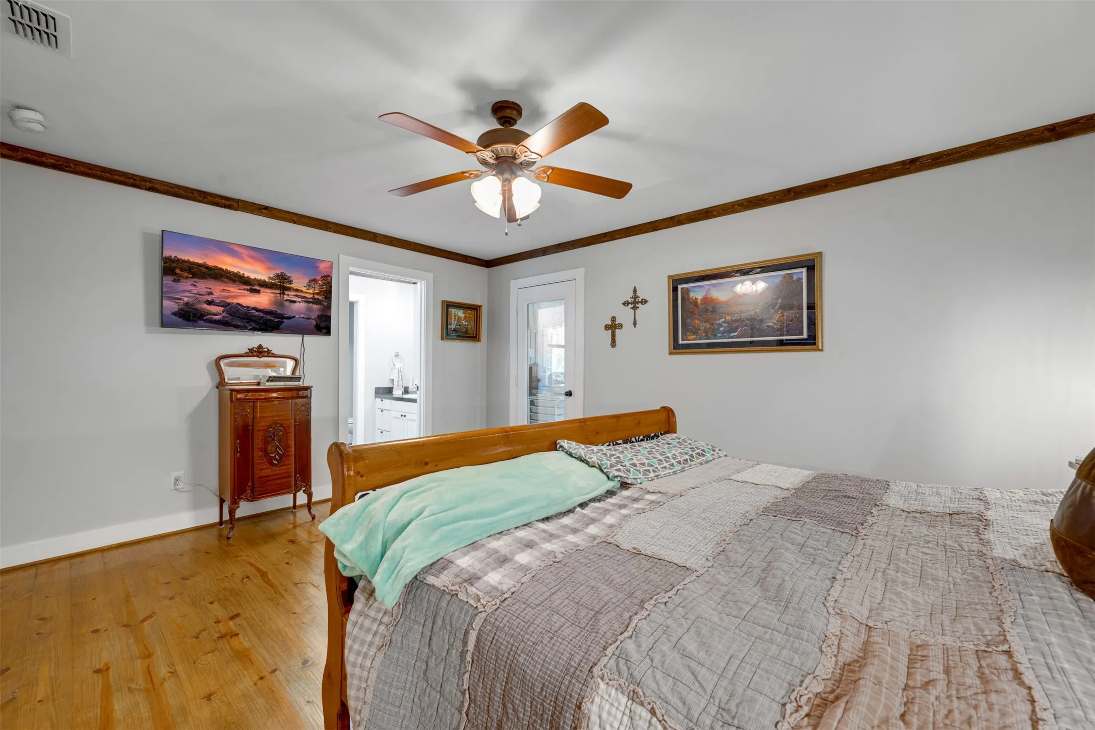 Hardwood flooring, wood-finish ceiling fan with integrated lighting, wood-finish trim, and white walls