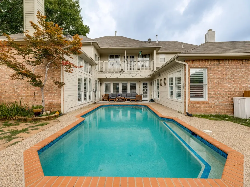 Back at house west facing the windows on ground level light up the kitchen and both living rooms. On second floor windows the game room looks out from a covered balcony on to pool.