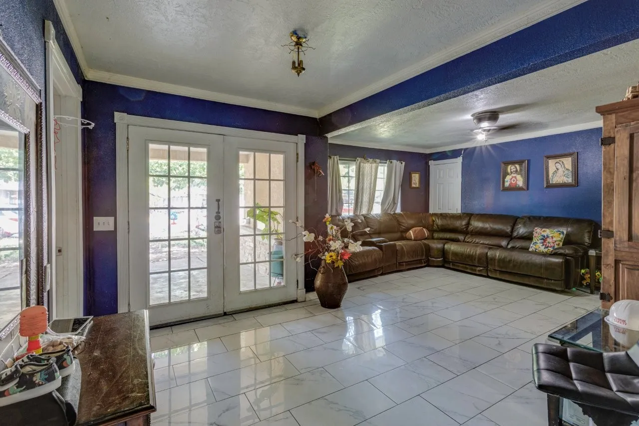 White tile flooring throughout, French doors with divided lites, and ceiling fans