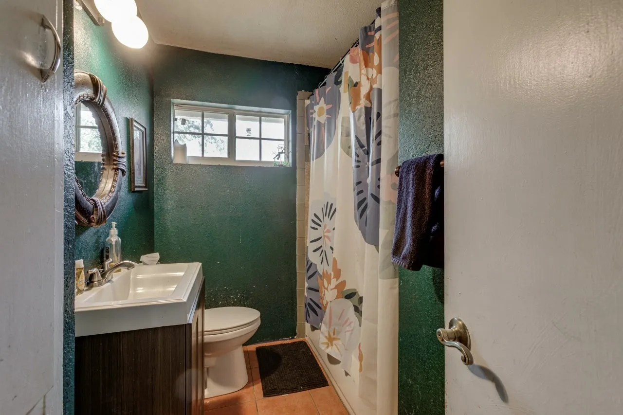 Bathroom featuring a window, toilet, vanity with integrated sink, and overhead lighting