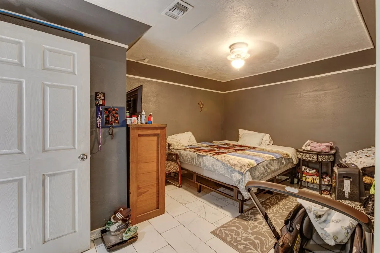 White paneled door, ceiling-mounted light fixture, and tile flooring