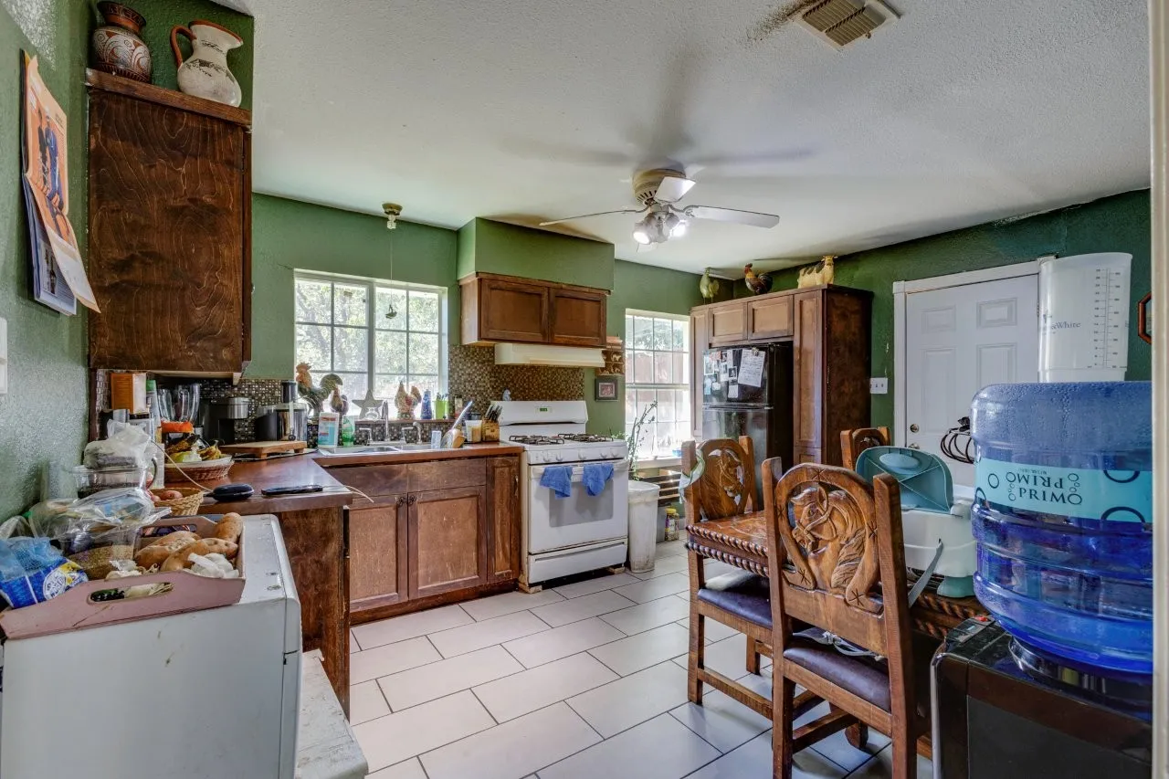 Kitchen featuring wood cabinetry, a white gas range, and tile flooring
