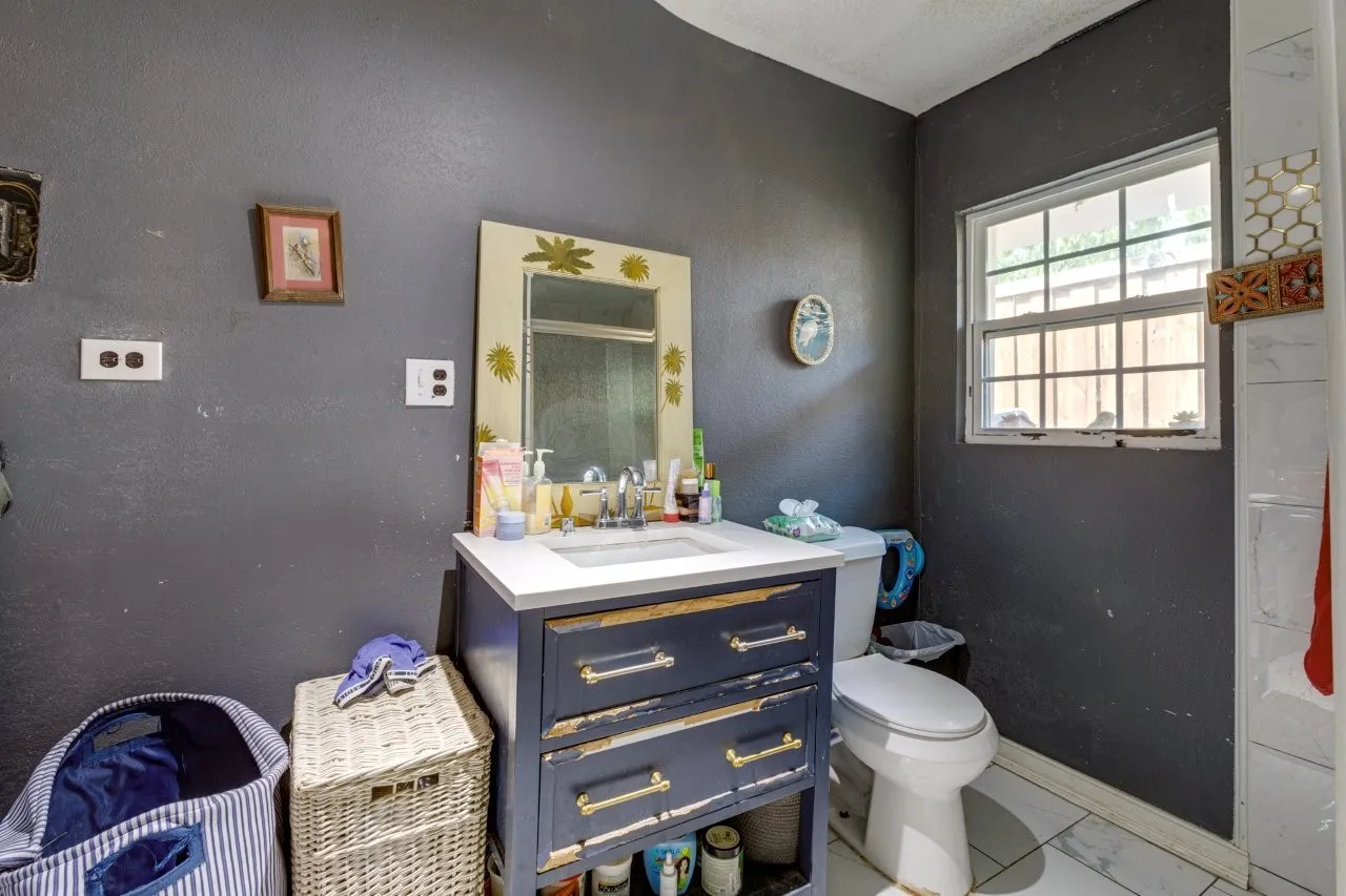 White-framed window with grid inserts, ceramic toilet, and vanity with a white countertop