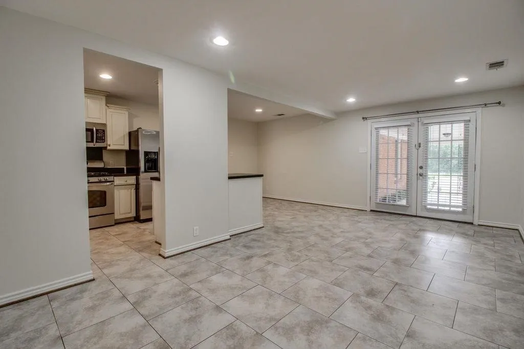 Tiled flooring throughout, recessed lighting, and double glass doors with interior blinds