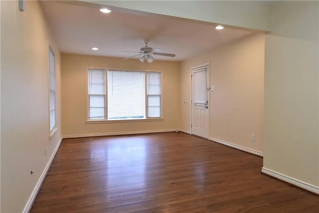 Warm wood-finish flooring, recessed lighting, and a ceiling fan with light kit